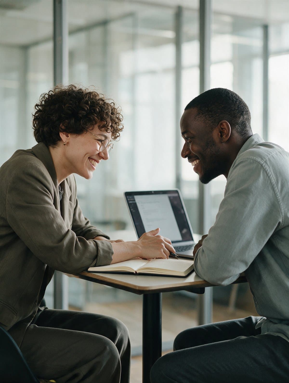 A recruiter interviewing a candidate in a glass meeting room